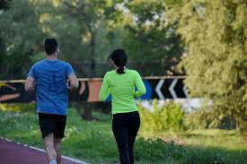 Um homem e uma mulher correm em uma pista.