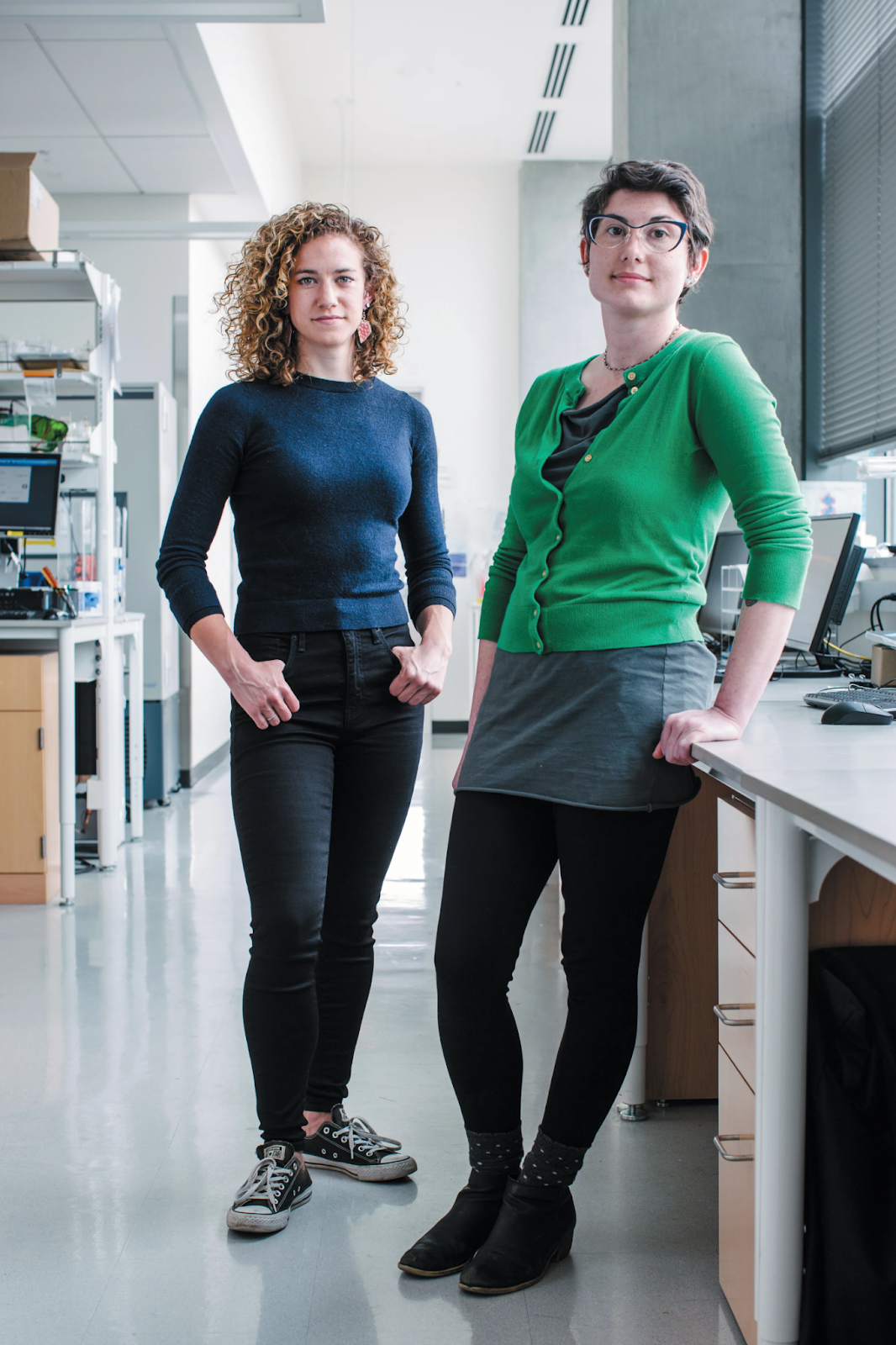 Duas cientistas em pé dentro de um laboratório.